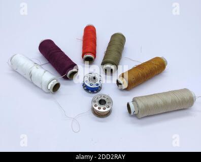 Old vintage hand sewing machine Colored thread coils or bobbin on white background, sewing machine accessories. selective focus. image Stock Photo