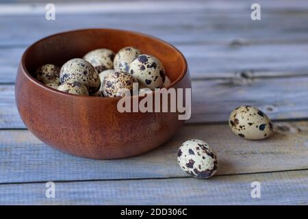 Quail eggs in wooden bowl on wooden background Stock Photo