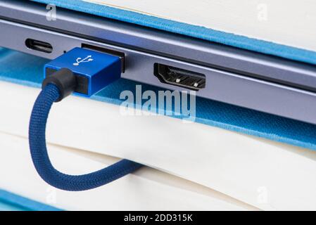 Usb cable connected to books, remote and e-learning concept Stock Photo