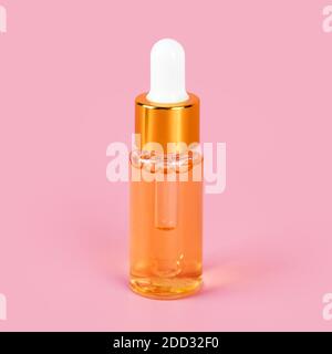 Skin care essence oil dropper glass bottle on pink background. Hydrating serum, vitamins for face skin. Anti aging serum with collagen and peptides in Stock Photo