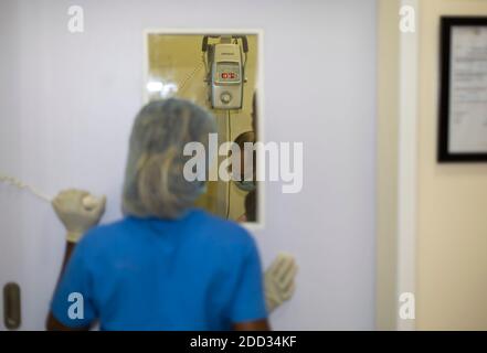 A Veterinary nurse waits outside an X-Ray room for a Veterinarian to complete an X-Ray of an animal Stock Photo