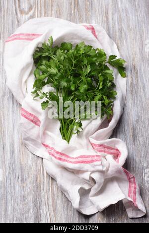 Fresh bunch of parsley on a wooden table, top view Stock Photo