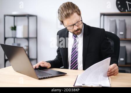 Businessman working with laptop and documents Stock Photo