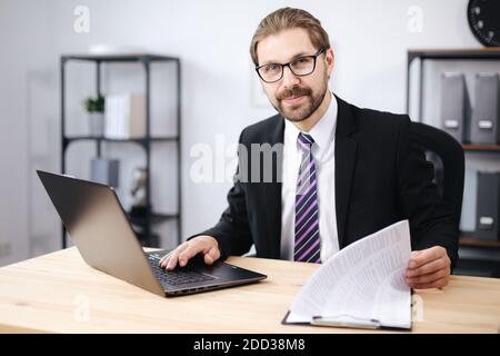 Happy man using laptop at office Stock Photo