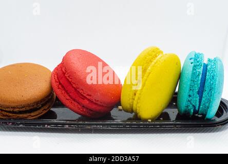Colorful macaroon cakes. Soft and colorful French macarons on a black stand Stock Photo