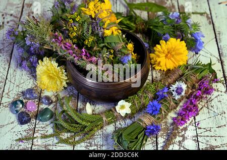 Bowl with herbs, plants and flowers on witch table.  Esoteric, occult and mystic concept, alternative medicine background with natural healing ingredi Stock Photo