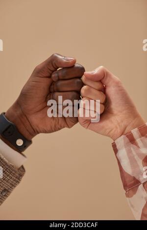 Close-up of two friends greeting each other isolated on beige background Stock Photo