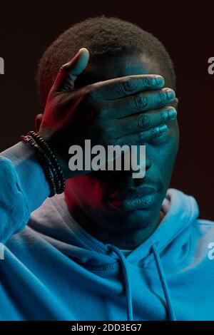 Close-up of African man covering his face with hand Stock Photo