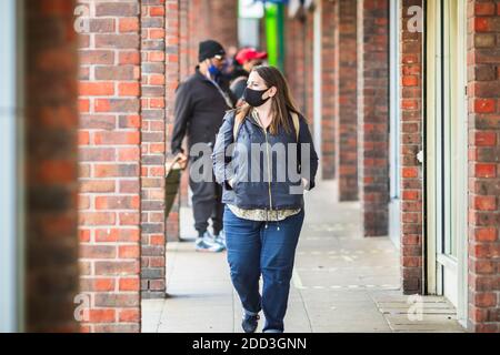 London, UK - 3 November, 2020 - A young caucasian woman wearing a face mask while shopping at Walthamstow market Stock Photo