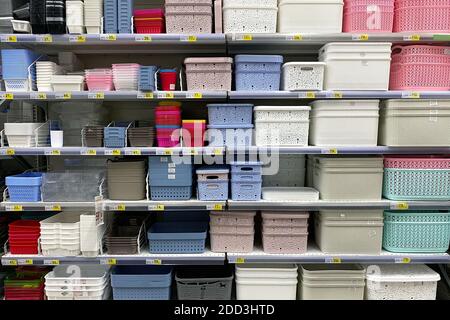Shelves in the store with plastic storage boxes. Inexpensive alternative to subjects made from natural materials. Colorful of plastic baskets and boxe Stock Photo