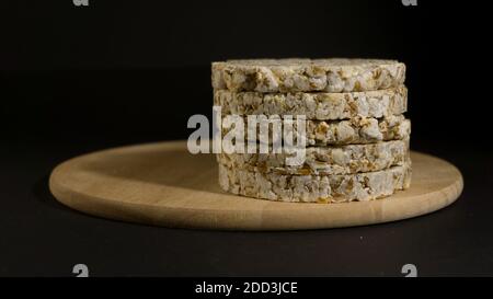 Grain crispbreads crispy rice and diet bread. Stack of puffed whole grain crispbread. Rice cake puffed rice on black background Stock Photo