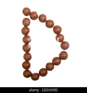 The letter 'D' written in brown chocolate Pepernoten, A traditional Dutch candy  for the Sinterklaas party on December 5th Stock Photo