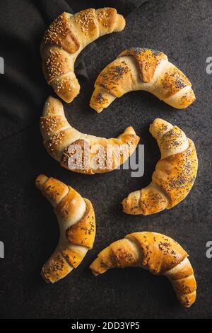 Salted croissant bun roll. Homemade pastry on black table. Top view. Stock Photo