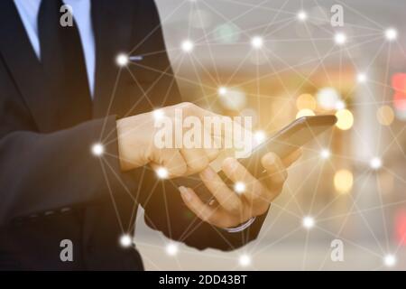 Close up of Businessman using smartphone with icon network. Man hand holding mobile phone for technology or internet banking concept. Stock Photo