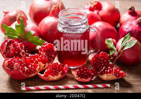 glass jar of pomegranate juice with fresh fruits on a wooden table Stock Photo