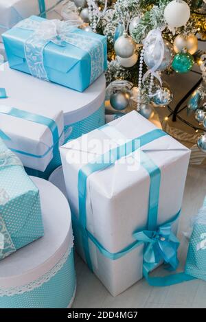 Christmas gift boxes with blue bow and bokeh lights on wooden surface Stock Photo