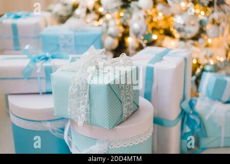Christmas gift boxes with blue bow and bokeh lights on wooden surface Stock Photo