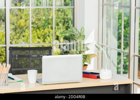 Back laptop computer putting on working desk, Workplace with notebook laptop on the table, Home interior or office background Stock Photo