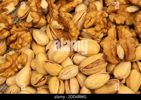 Pistachios and walnuts lie on the sacking. Close up Stock Photo