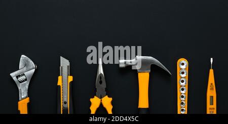 Set of tools on Labor Day greeting card with copy space for text. Flat design. DIY concept. Collection of instruments on a black background. A kit of Stock Photo