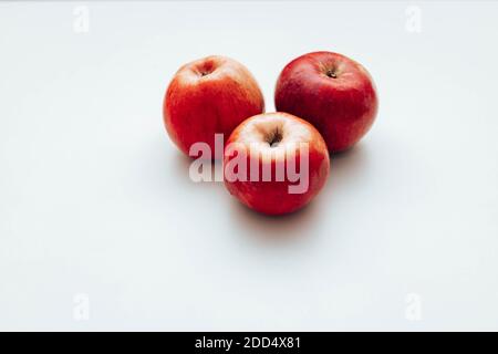 Three red juicy apples on white table. Space for text Stock Photo