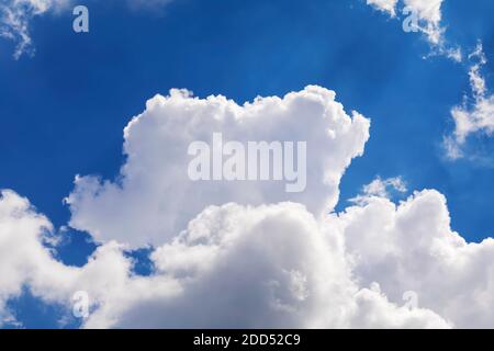 Dramatic white clouds float in the blue sky. Stock Photo