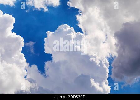 Dramatic white clouds float in the blue sky. Stock Photo