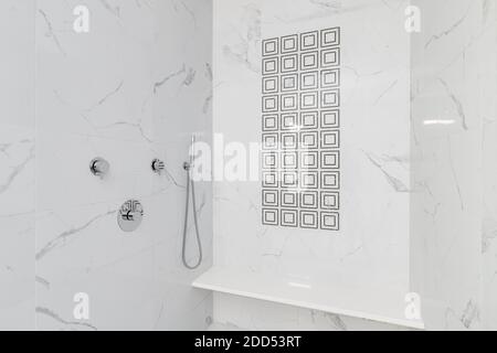 https://l450v.alamy.com/450v/2dd53rt/a-custom-tiled-shower-and-bench-with-white-marble-on-the-walls-and-black-tiled-squares-in-a-pattern-2dd53rt.jpg