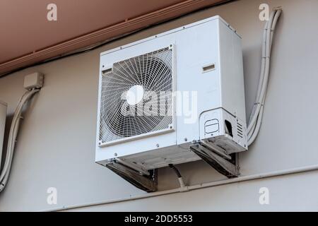 Outdoor Air conditioning unit mounted on wall used for cooling space Stock Photo