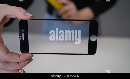 Glass from the phone close-up. Protective glass for the phone in hands. Stock Photo
