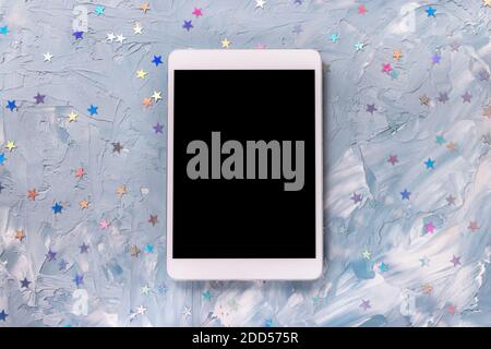 Colorful foil stars confetti decoration and tablet Stock Photo