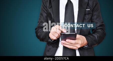 CONTACT US. Businessman hand using mobile phone. Communication concept. Stock Photo