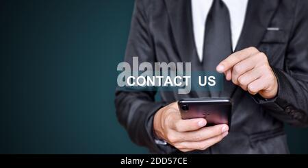 CONTACT US. Businessman hand using mobile phone. Communication concept. Stock Photo