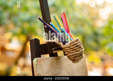 Colored pencils tied with a rope in garden for kid zone Stock Photo