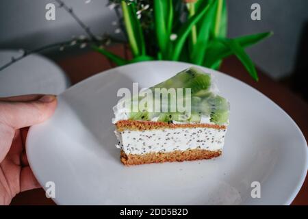 Raw vegan kiwi green cake decorated with slices. Coconut chia filling jelly vegetarian cashew cream cheesecake gluten free. Lactose sugar free holiday Stock Photo