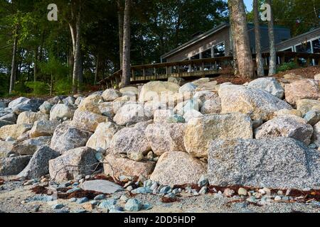 A manmade wall of rocks, stones, riprap, lines a shoreline. The project ...