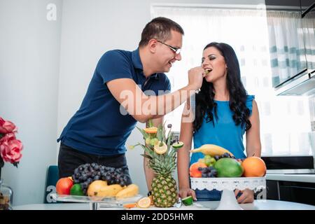 Happy married couple eating fruits. Healthy activity, indoors, cold prevention Stock Photo