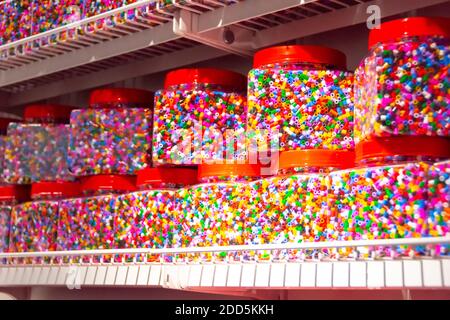 A small multi-colored mosaic in jars to create various shapes in a person's fantasy. Tweezers and mosaic plate Stock Photo