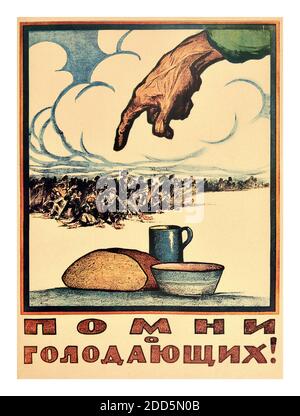 Vintage 1920’s Russian Soviet Government propaganda poster with the caption 'Remember the Hungry!'. 'Proletarians of all nations, unite!' The artwork features a loaf of bread, mug and bowl, with a large hand from above pointing to a malnourished crowd of people in the distance. The Russian famine of 1921–22, also known as the Povolzhye famine, was a severe famine in the Russian Soviet Federative Socialist Republic which began early in the spring of 1921 and lasted through 1922. This famine killed an estimated 5 million people. Stock Photo