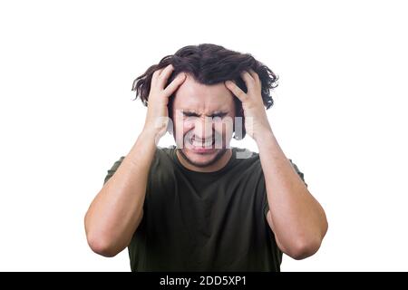 Frustrated, mad young man messing up and pulling his hair, hands to head, eyes closed screaming and clenching teeth isolated on white. Stressed guy ne Stock Photo