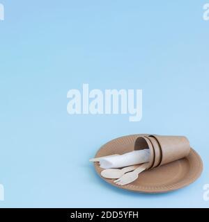 Disposable eco friendly bamboo wood and paper utensils on blue background. Space for your text Stock Photo