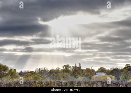 Sun rays through a dark cloud in this photo taken from the meadow at Runnymede in Egham on an overcast autumn day Stock Photo