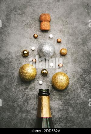 New Years Eve celebration concept background.Champagne bottle with Christmas balls on gray background Stock Photo