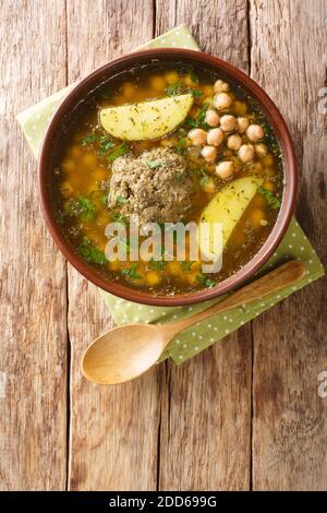 Homemade Kufta bozbash is a traditional Azerbaijani meatball soup and chickpea close-up in a plate on the table. Vertical top view from above Stock Photo