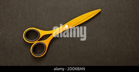 Scissors gold color isolated on black background, Tailor, barber, hairdresser luxury equipment, top view Stock Photo