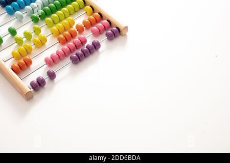 School abacus with colorful beads on white color background, close up view, copy space. Kids learning count, children math class concept Stock Photo