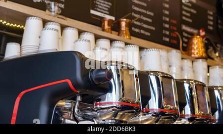 Coffee machine, cafe shop. Espresso professional maker closeup view. Stainless steel equipment and paper cups, takeaway service Stock Photo