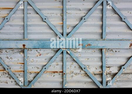 texture of a gray, rusted metal surface with light blue metal struts, weathered, peeling paint Stock Photo