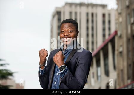 Happy businessman raising his fists in the gesture of winning and shouting. Excited businessman celebrating successful business out of offices. busine Stock Photo