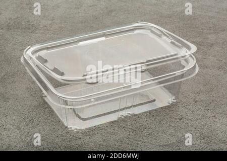 Disposable plastic transparent lunch box on a gray concrete background. Stock Photo